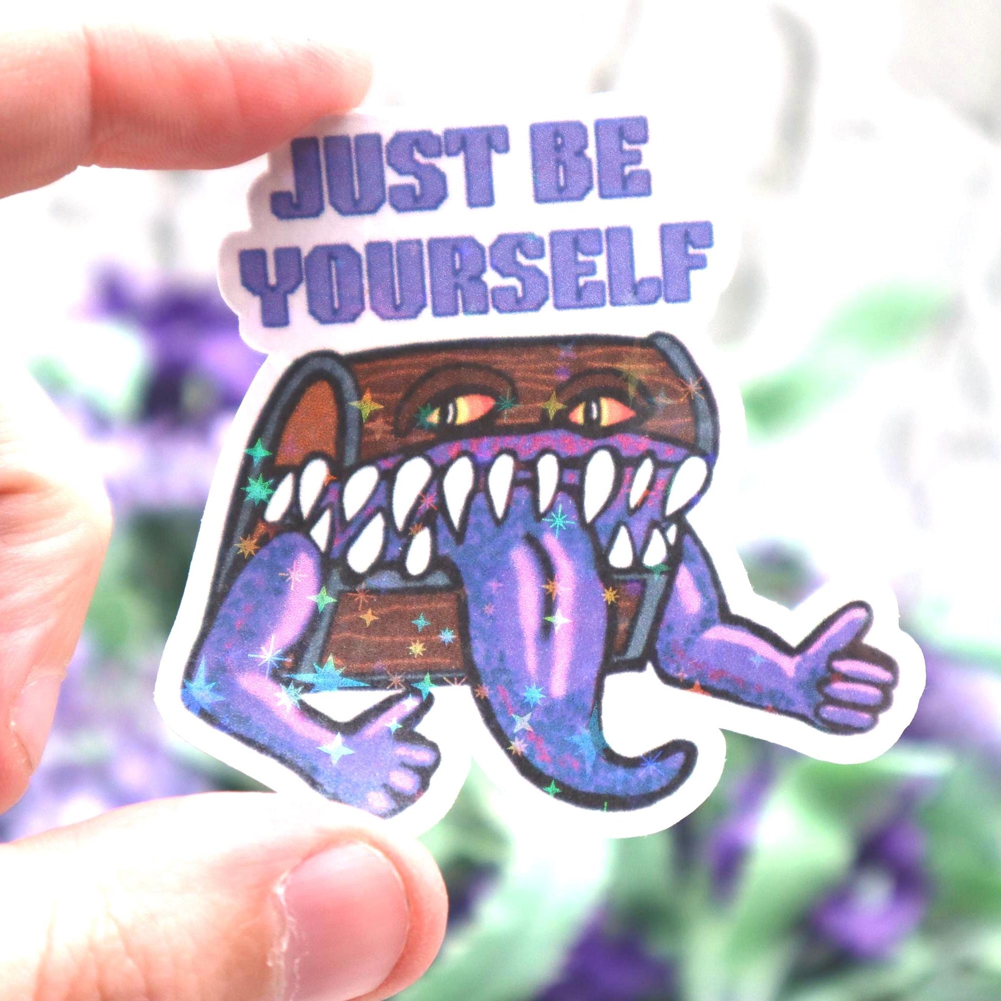 Holographic DnD mimic sticker with a grinning treasure chest and the phrase Just Be Yourself, perfect for laptops, water bottles, and tabletop RPG fans.