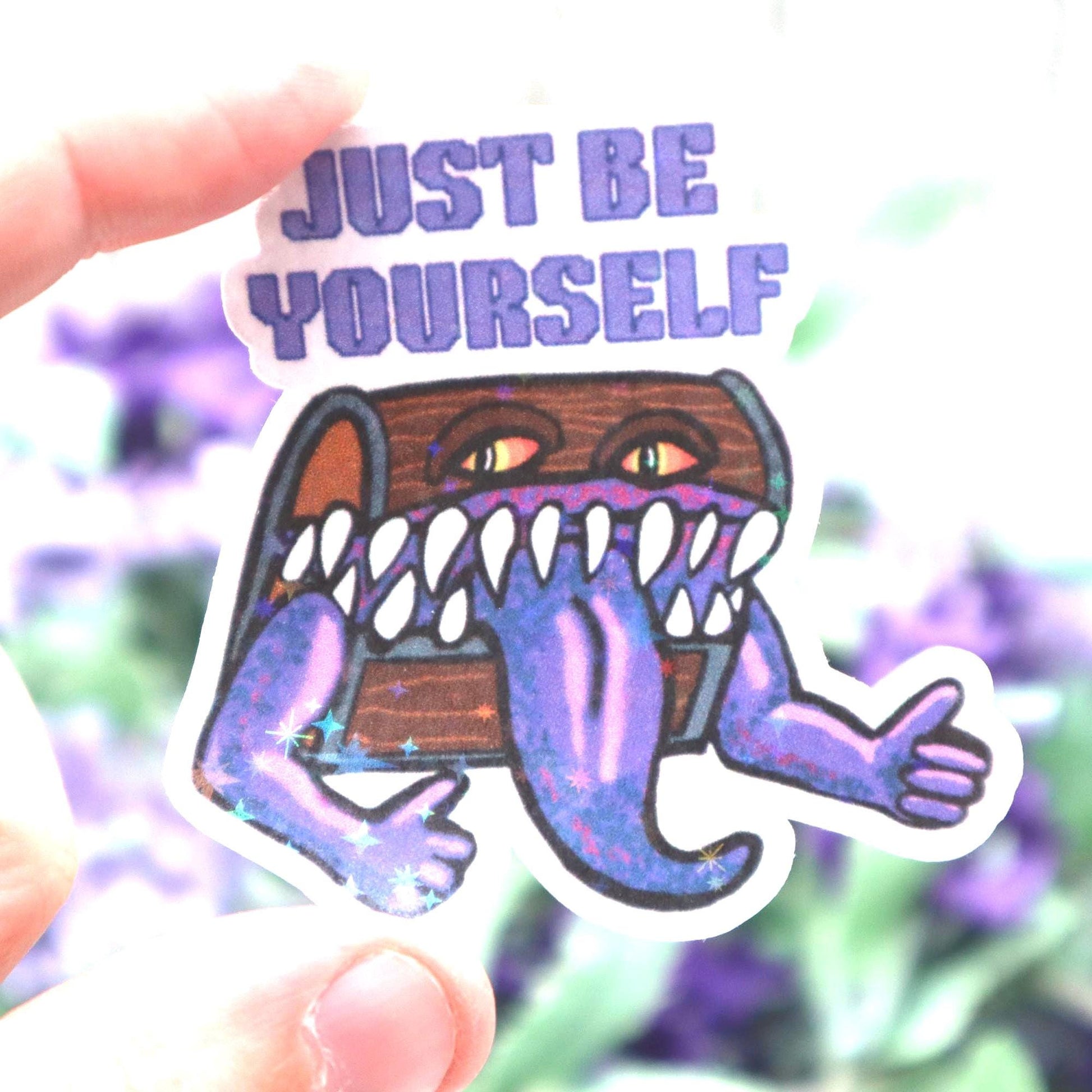 Holographic DnD mimic sticker with a grinning treasure chest and the phrase Just Be Yourself, perfect for laptops, water bottles, and tabletop RPG fans.