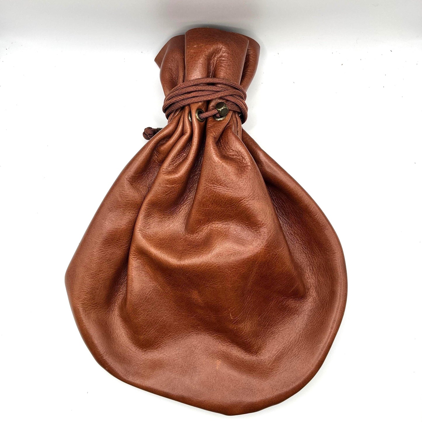 Handcrafted leather dice bag with drawstring, ideal for storing RPG dice sets. Perfect for DnD, tabletop games, or as a fantasy gift for gamers.