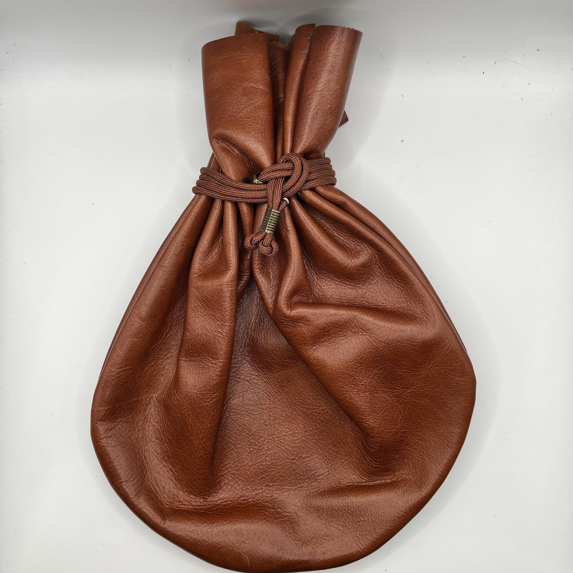 Handcrafted leather dice bag with drawstring, ideal for storing RPG dice sets. Perfect for DnD, tabletop games, or as a fantasy gift for gamers.