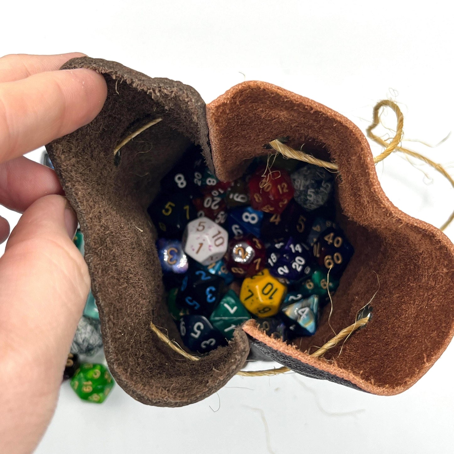 Handcrafted leather dice bag with drawstring, ideal for storing RPG dice sets. Perfect for DnD, tabletop games, or as a fantasy gift for gamers.