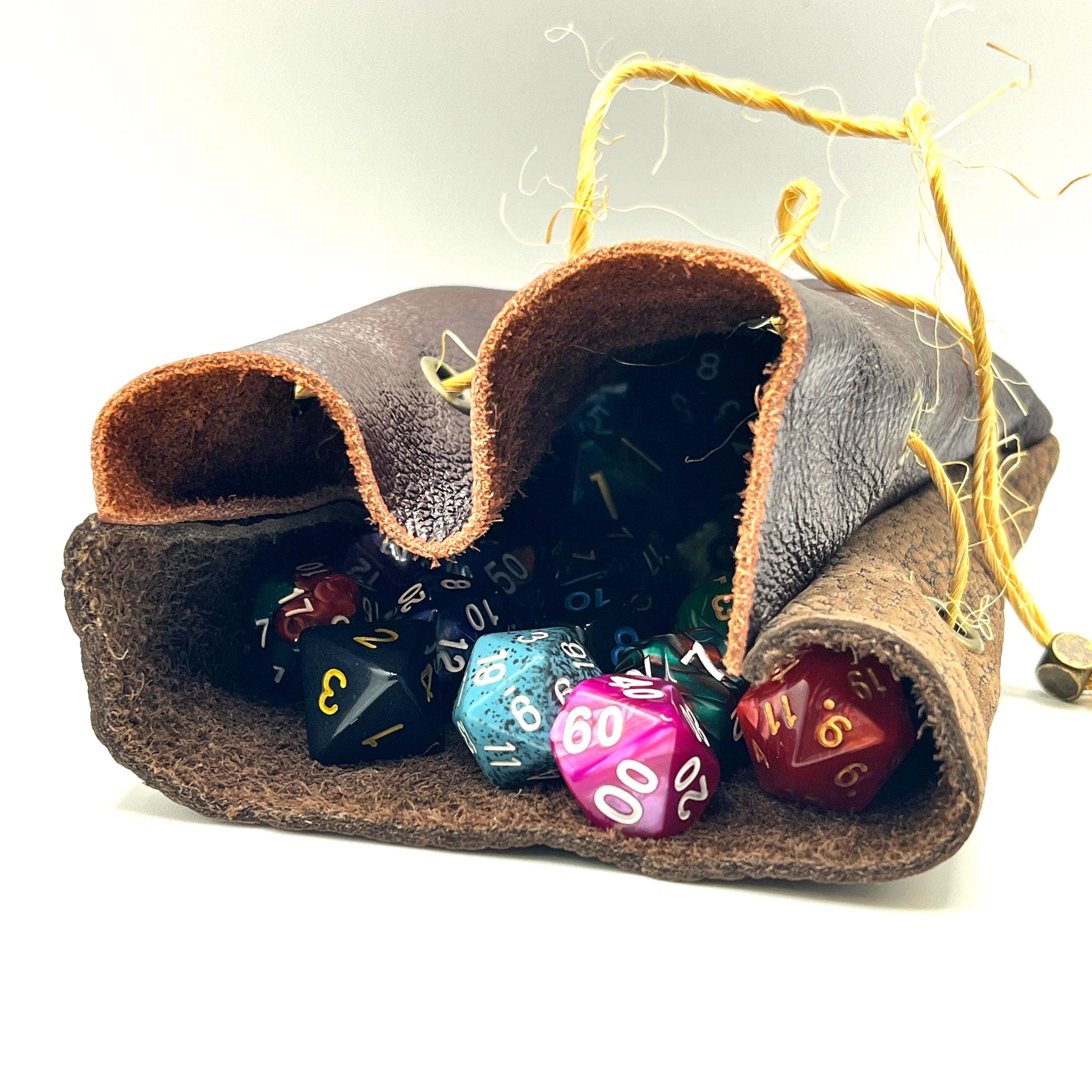 Handcrafted leather dice bag with drawstring, ideal for storing RPG dice sets. Perfect for DnD, tabletop games, or as a fantasy gift for gamers.