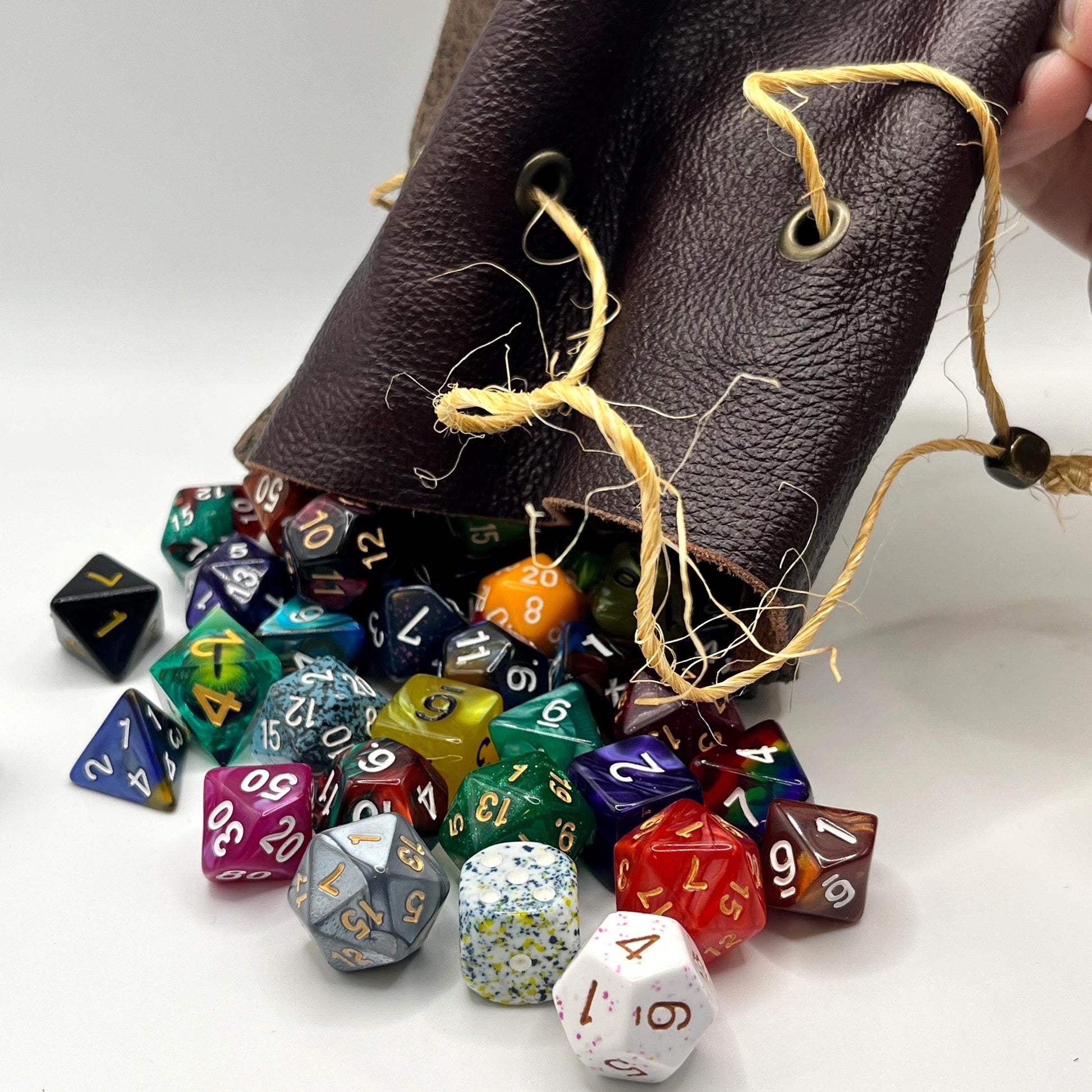 Handcrafted leather dice bag with drawstring, ideal for storing RPG dice sets. Perfect for DnD, tabletop games, or as a fantasy gift for gamers.