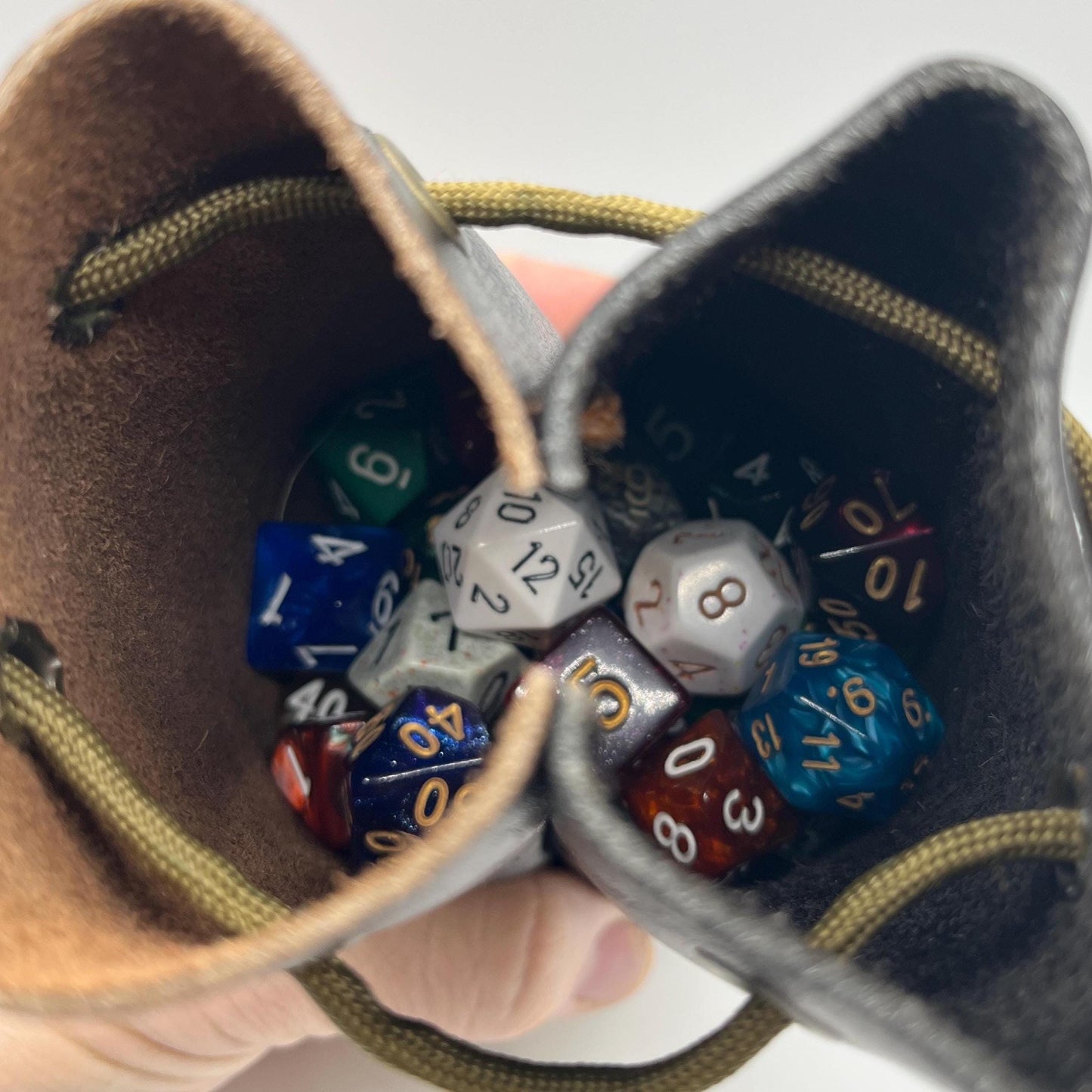 Handcrafted leather dice bag with drawstring, ideal for storing RPG dice sets. Perfect for DnD, tabletop games, or as a fantasy gift for gamers.