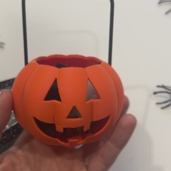 Cute Halloween clicker set with glow-in-the-dark ghost, candy corn, chocolate bat, and wrapped candy fidget toys in a festive pumpkin pail container.