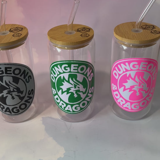 16 oz Dungeons and Dragons glass coffee can with vinyl fantasy design, bamboo lid engraved with two D20 dice, and straw. Custom colors available. Handwash only; not dishwasher or microwave safe.