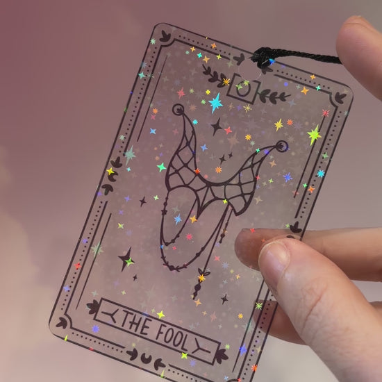 Clear holographic tarot card bookmark with elegant black line art on transparent waterproof cardstock. Finished with a black tassel and shimmering holographic pattern that changes in the light. Available in all 22 Major Arcana designs.