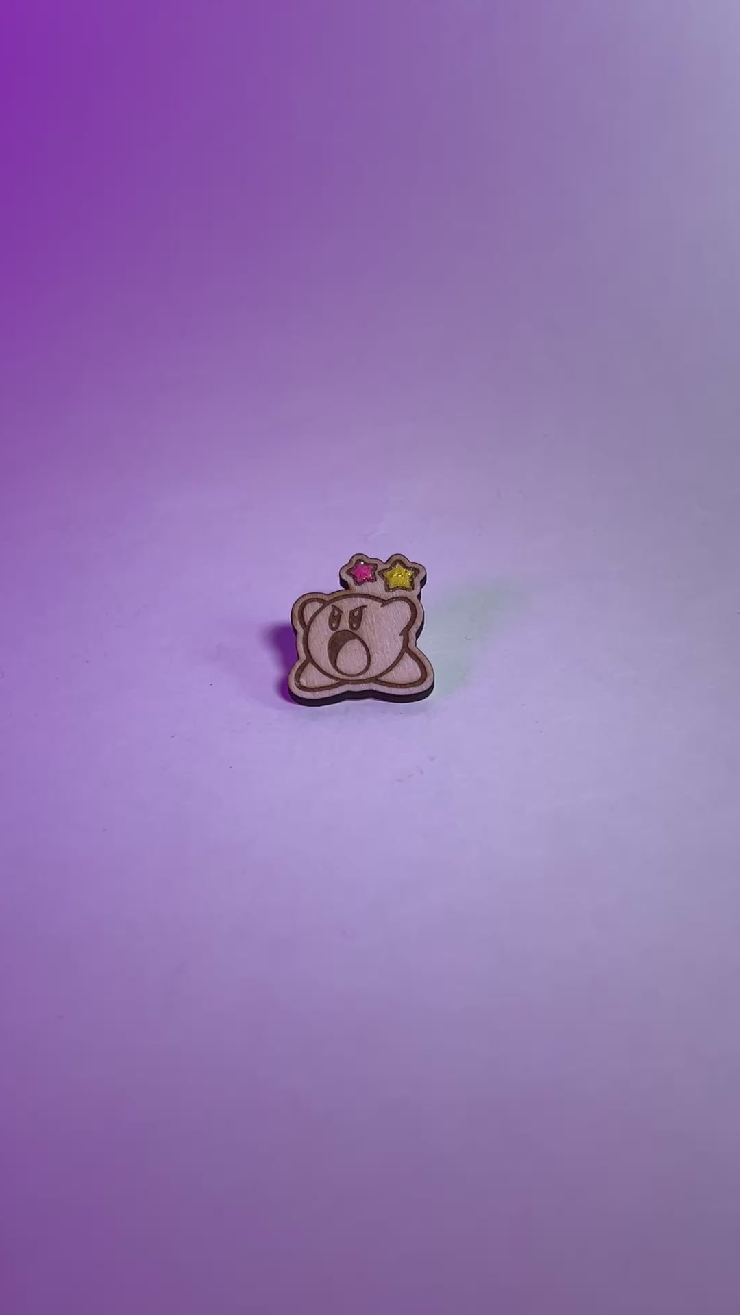 Cute Kirby wood pin with laser engraving and glittery star accents. Handmade gamer brooch for Nintendo fans, perfect for jackets or bags.