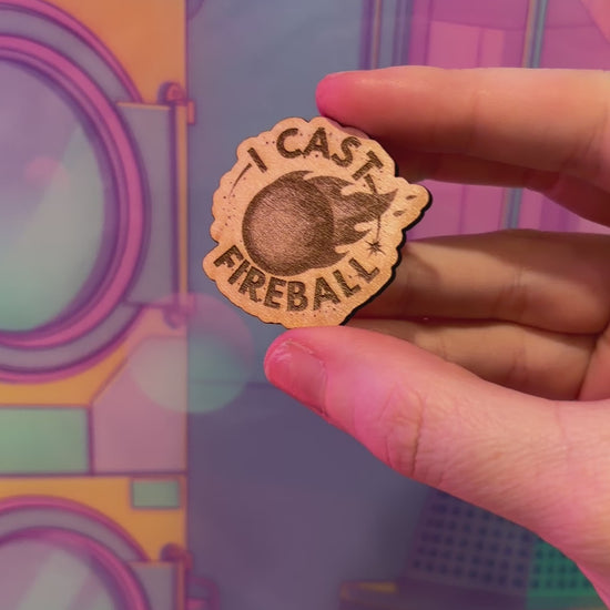 Laser engraved basswood pin reading "I Cast Fireball" for tabletop gamers.