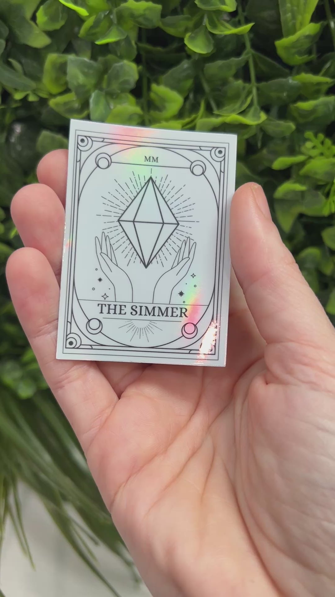 Silver Holographic Sims tarot card sticker featuring "The Simmer" with a radiant plumbob design. A must-have for Sims fans, gamers, and lovers of geeky decor.