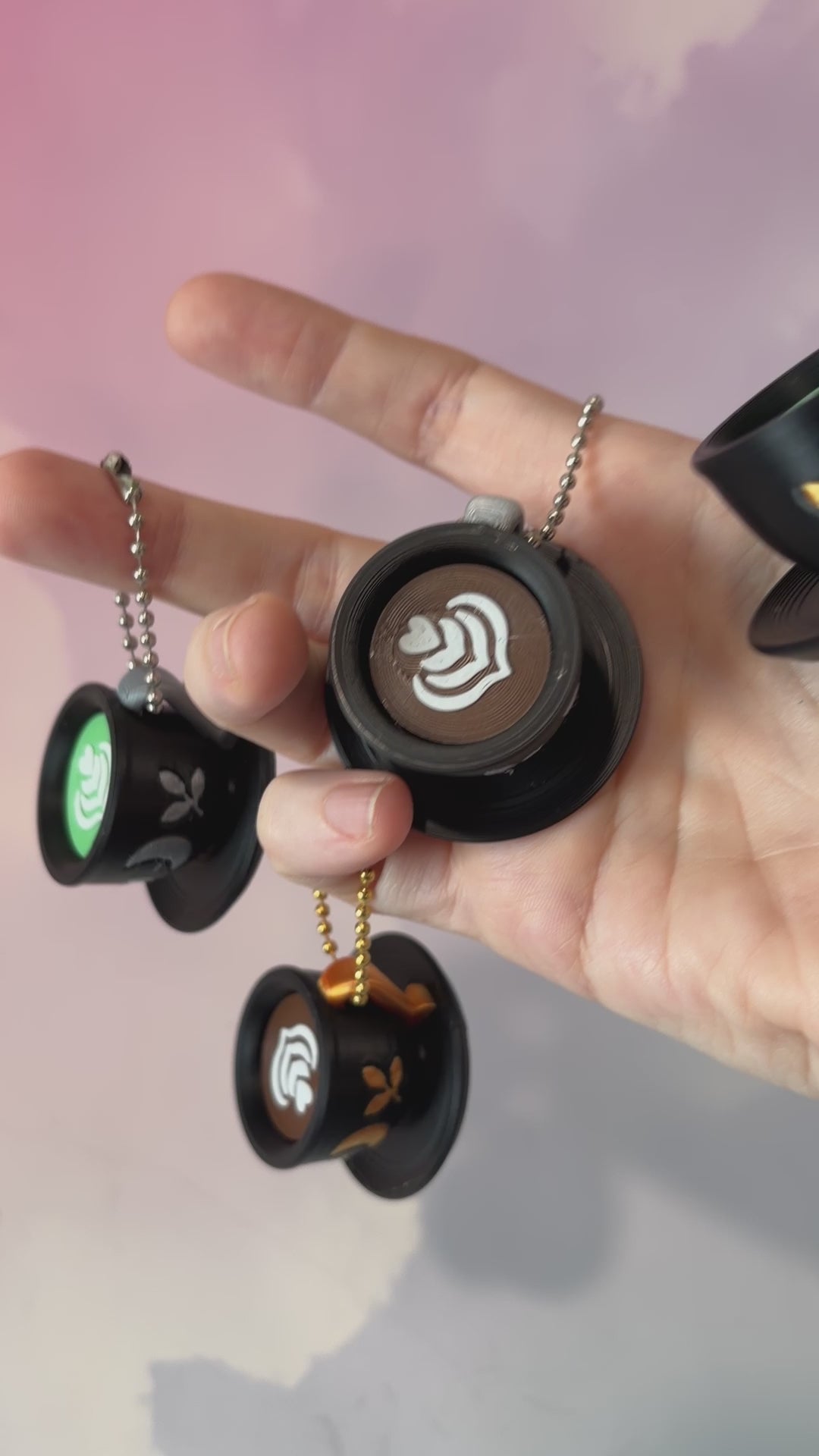 3D printed mystical drink cup fidget clicker keychain with a black floral moon design in gold or silver. Choose matcha or coffee with cute latte art, plus a clicky or silent mechanism.