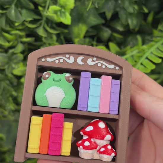 4-key bookcase fidget clicker keychain with books, frog, and mushroom.