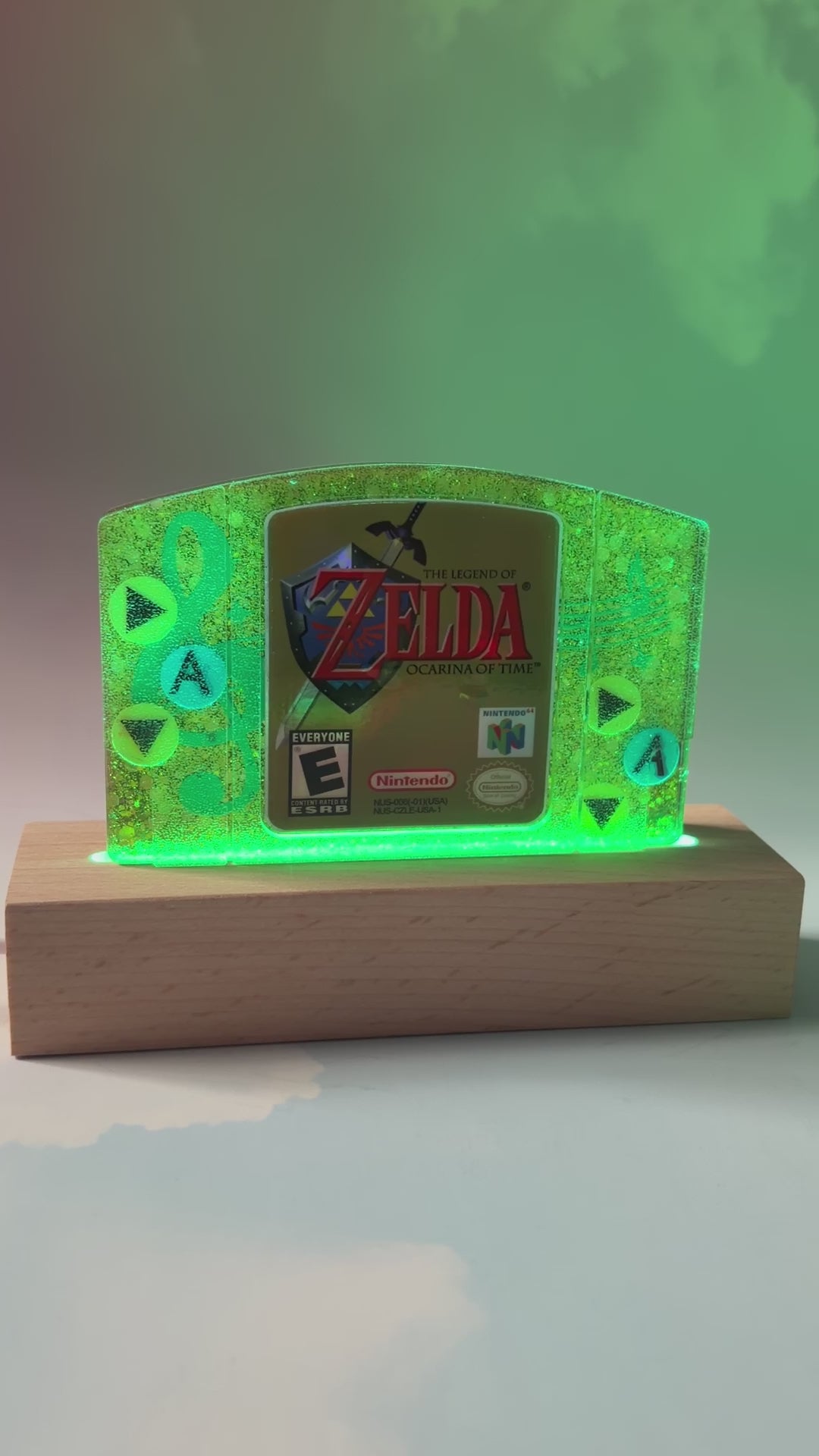 This handmade Zelda Ocarina of Time resin cartridge features vibrant custom art, adding a nostalgic touch for retro gaming fans. Ideal as a unique gift or display piece for collectors and gamers alike. 