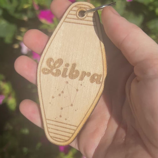 Laser engraved wood motel keychain featuring zodiac names and constellations, perfect for astrology lovers, horoscope fans, and retro gift collectors.