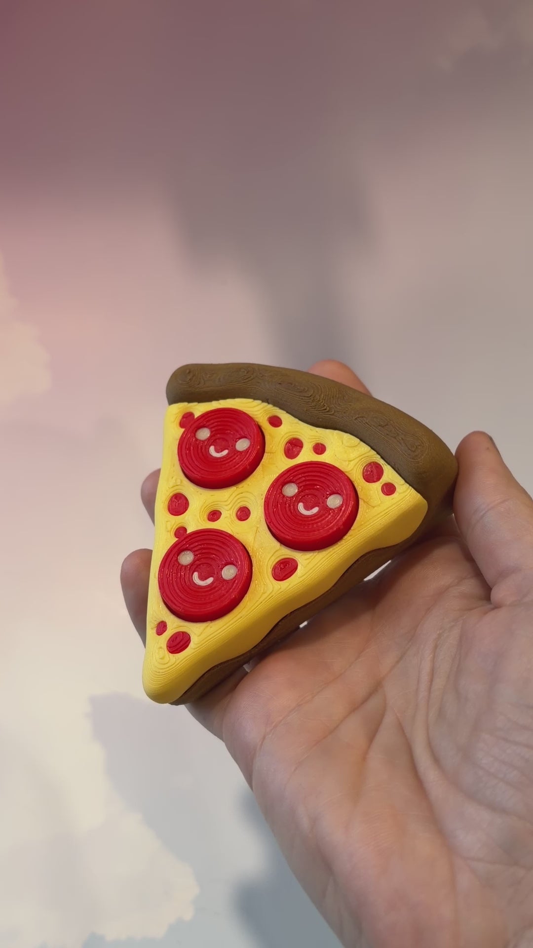 Pizza slice fidget clicker with smiley pepperoni toppings.
