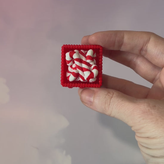 3D printed Christmas fidget clicker featuring a red basket filled with red-and-white candy canes. Available with a clicky or silent mechanism. A festive holiday sensory toy and stocking stuffer for Christmas lovers.