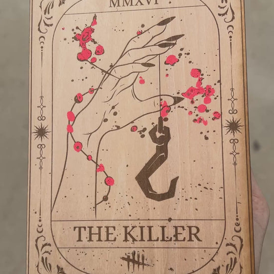 Laser engraved wooden tarot card featuring “The Killer” inspired by Dead by Daylight with red foiled accents. Horror-themed gamer decor perfect for fans of spooky games and tarot.