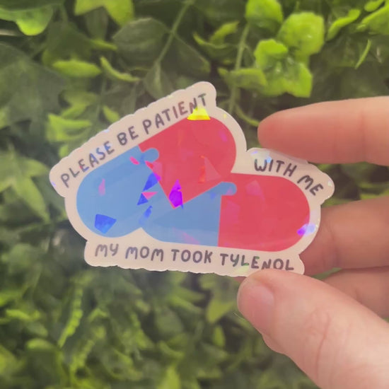 Holographic sticker featuring two pills and the phrase “Please be patient with me my mom took Tylenol.” Funny, shiny mental health vinyl decal for laptops, water bottles, and more.